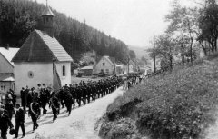 členové hasičského sboru procházejí kolem dnes již neexistující kaple