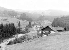 historické foto kaple (v pozadí, mezi dvojicí smrků a domem vlevo od středu)