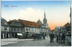 historické foto města se zvonicí (v pozadí)