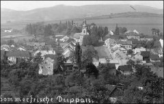 historické foto města s kaplí (v pozadí na kopci u šipky)