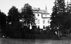 historické foto špiče věže kostela nad střechami