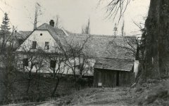 špička věže kostela za střechou domu