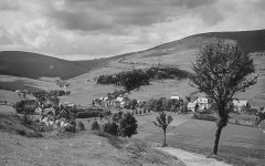 historické foto vsi s kostelem (vlevo)