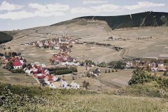 historické foto vsi s kostelem (vlevo)