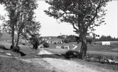 historické foto vsi s kostelem (v pozadí)