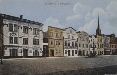 dobová pohlednice města s kostelem (věž za domy)