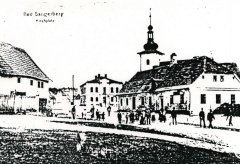 náves s kostelní věží v pozadí