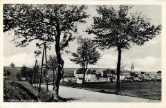 historické foto města s kostelem (vpravo od stromu)