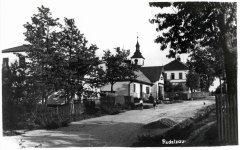 historické foto vsi s kostelem (věž v pozadí)