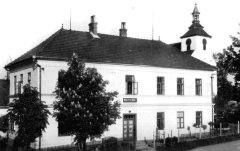 vykukující věž kostela za budovou školy