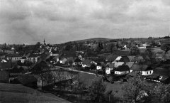 historické foto vsi s kostelem (v pozadí vlevo)