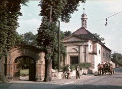 historické foto kostela s bývalou hřbitovní bránou (vlevo)