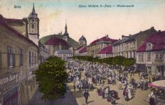 dobová pohlednice starého Mostu s kostelem (vlevo)