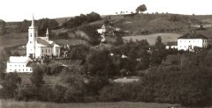 historické foto vsi s kostelem (vlevo)