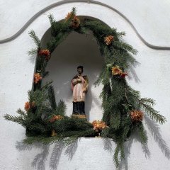 detail sošky sv. Jana Nepomuckého ve výklenku na vchodem