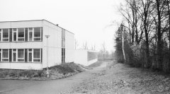 novostavba školy na místě hrobů, vpravo zbytek hřbitovní zdi