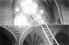 nacistický pyrotechnik ukládá výbušninu nad vchodem do synagogy