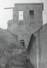 částečně zřícená stavba před demolicí