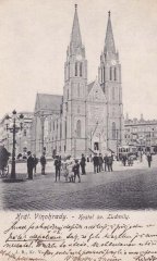 historické foto věží synagogy (vpravo od kostela nad střechami)
