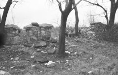 pobořená ohradní zeď a trosky náhrobků