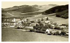 dobová pohlednice vsi s kostelem (vlevo)