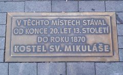pamětní deska v dlažbě náměstí s informací o bývalém kostele