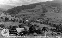 historické foto vsi s kostelem (v pozadí vpravo)