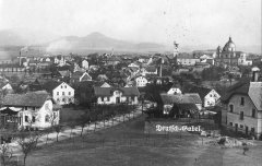 dobová pohlednice města s kostelem (vlevo)