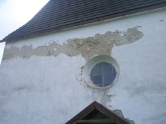 detail poškozené omítky nad vstupem