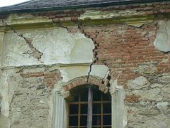 detail poškození fasády a okna