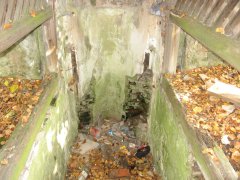 poničená studánka při zadní stěně kostela