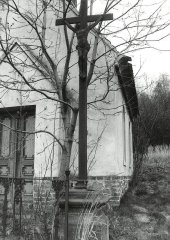 litinový kříž před vchodem do kaple