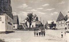 historické foto vsi Fláje s kostelem (v pozadí)