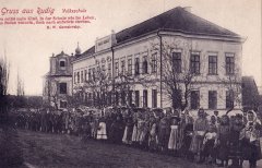 dobová pohlednice s motivem školy a kostelem za ní
